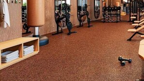 Una palestra con pareti in legno, attrezzature per esercizi e pavimento rivestito a moquette.