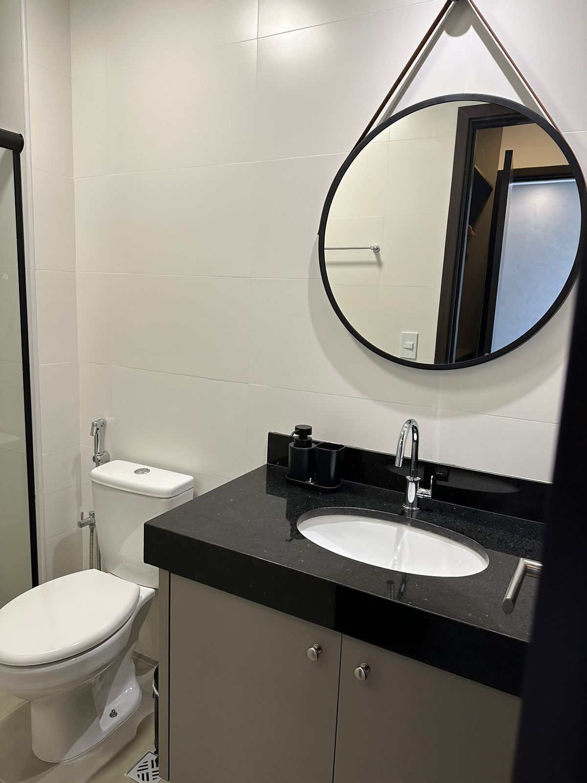 Ein modernes Badezimmer mit Toilette, Waschbecken und Spiegel.
