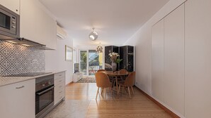 Eine moderne Küche mit Essbereich, ausgestattet mit einem Backofen, einer Mikrowelle und einer gemusterten Spritzschutzwand.