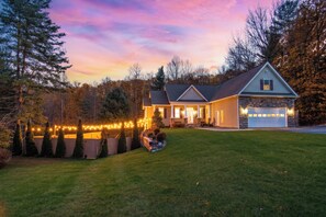 A two-story house with a stone facade, a garage, and a well-maintained lawn.