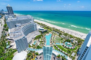 A high-rise hotel with a pool area, beach access, and a view of the ocean. - Jr Suite Presidential Design Ocean Fontainebleau (Miami Beach)
