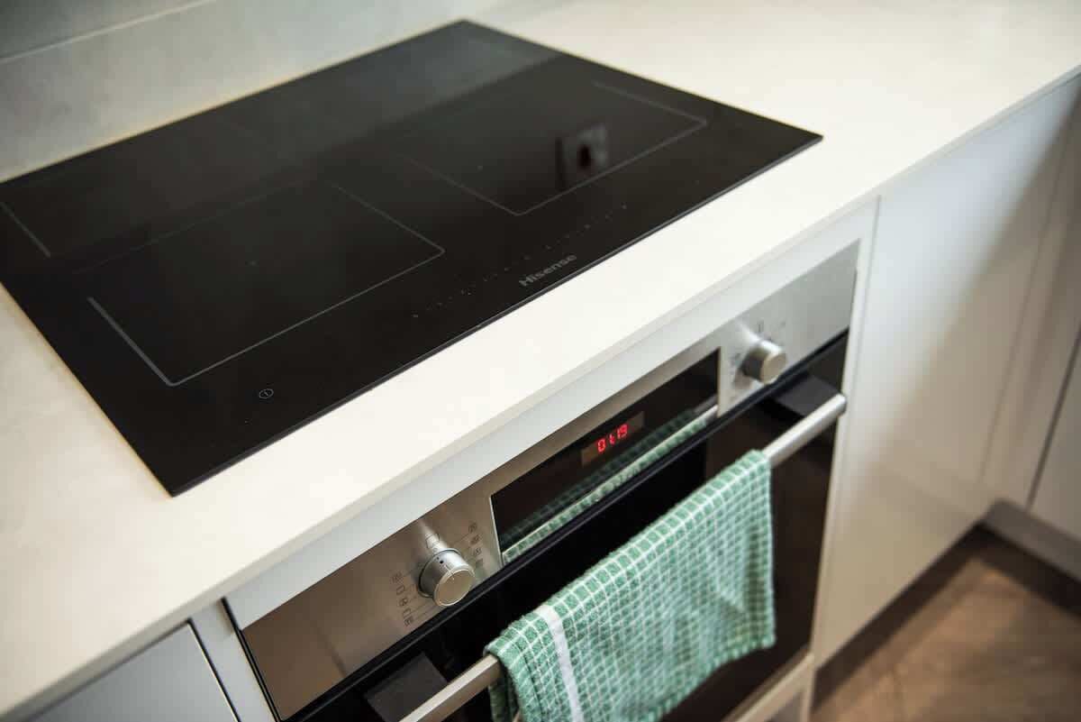Eine moderne Küche mit Induktionskochfeld und einbauendem Backofen.