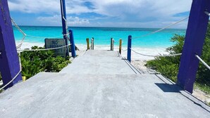 Un camino de hormigón que lleva a una playa, con un cartel que dice 'NO LIFEGUARD DUTY'.