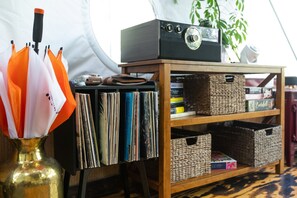 Una estantería con discos de vinilo, una radio y una planta.