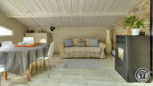 A cozy living room with a dining table, a sofa, and a kitchen area with a stove.