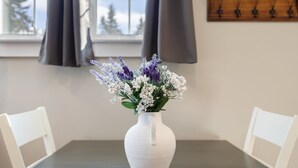 A white vase with flowers on a table.