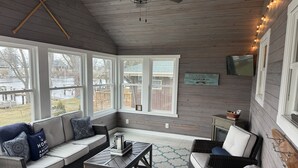 A cozy room with a sofa, chairs, and a TV.