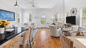 A spacious living room with a large sofa set, a dining table, wicker chairs, and a ceiling fan. - Sugar Blue, walk to the beach
 (Santa Rosa Beach)