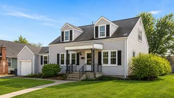 A two-story house with a front porch, a garage, and a well-maintained lawn.