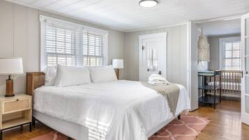 Un dormitorio con una cama grande, mesitas de noche, un escritorio y una silla.