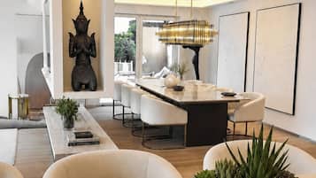 A modern living room with a dining area, a statue, and a large window.