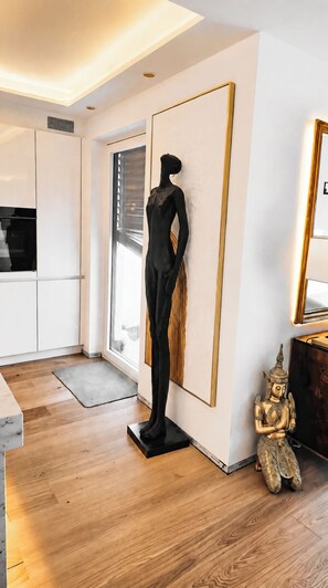 Ein modernes Interieur mit einer Passionsfigur, einer Buddha-Statue und einem großen Spiegel.