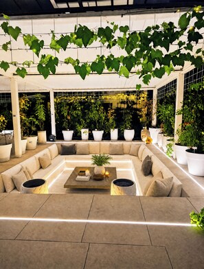 A modern lounge area with a sofa, coffee table, and potted plants. - Luxurious Large Home + Pool + Garden + Koi Pond (München)