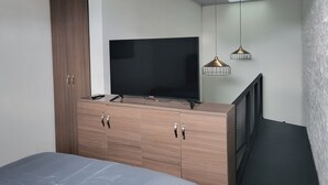 A bedroom with a bed, a TV on a wooden dresser, a wardrobe, and pendant lights. - 1. Tranquilo Apartamento Duplex - Carrera 23 C 69 -10 Manizales Caldas. Colombia (Manizales)