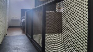 A narrow hallway with a metal railing, a bed, and a small table. - 1. Tranquilo Apartamento Duplex - Carrera 23 C 69 -10 Manizales Caldas. Colombia (Manizales)