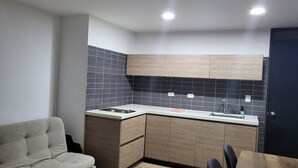 A modern kitchen with a built-in stove, wooden cabinets, and a black tiled backsplash. - 1. Tranquilo Apartamento Duplex - Carrera 23 C 69 -10 Manizales Caldas. Colombia (Manizales)