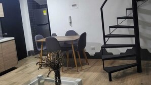 A modern kitchen with a dining area, a staircase, and a small table with a vase. - 1. Tranquilo Apartamento Duplex - Carrera 23 C 69 -10 Manizales Caldas. Colombia (Manizales)