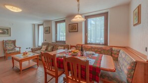 A dining area with a table set for four, surrounded by wooden chairs and a bench. -  CHALET PONTAL 5 - Relax with a beautiful view of the mountains (Courmayeur)