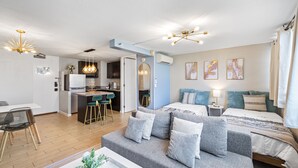Eine moderne Wohnung mit Wohnbereich, Küchenzeile und Schlafzimmer.