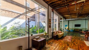 A spacious living area with large windows, a wooden ceiling, and a cozy seating arrangement. - Downtown Lynchburg *REAL loft living* Va Virginia (Lynchburg)