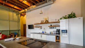 A modern kitchen with a central island, white cabinets, and a built-in refrigerator. - Downtown Lynchburg, Panel Loft, LYH Va Virginia (Lynchburg)