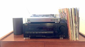 A TEAC audio system on a wooden cabinet with a stack of CDs to its right.
