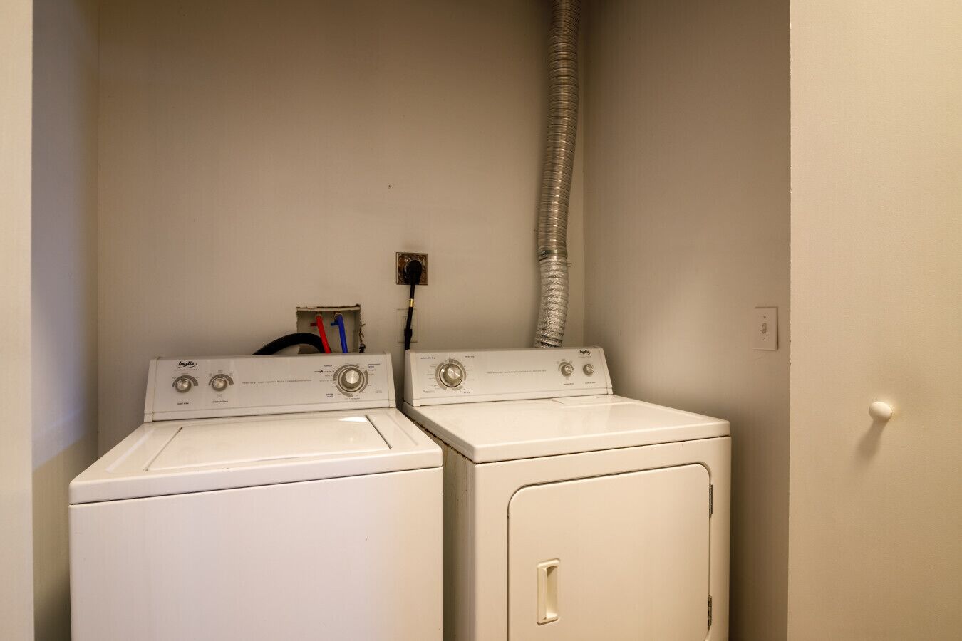 A laundry area with two white front-loading washers and a dryer.