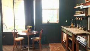 A compact kitchen with a dining area, a window with a view, and a built-in stove. - Downtown Lynchburg, Vintage Courtyard Loft, Va (Lynchburg)