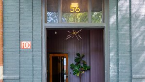 A building entrance with a number '56' above the door, a fire hydrant, and a potted plant. - Downtown Lynchburg, Vintage Courtyard Loft, Va (Lynchburg)