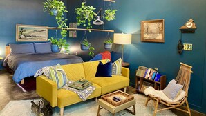 A cozy living room with a yellow sofa, a wooden chair, and a bookshelf. - Downtown Lynchburg, Vintage Courtyard Loft, Va (Lynchburg)