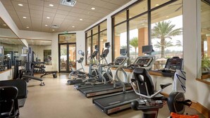 Una palestra con tapis roulant, cyclette e macchinari per l'allenamento con i pesi.