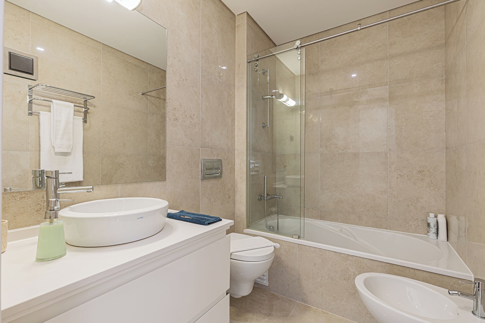 A modern bathroom with a glass-enclosed shower, a white sink, and a separate bathtub.