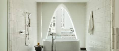 A modern bathroom with a freestanding bathtub, a shower, and a toilet.