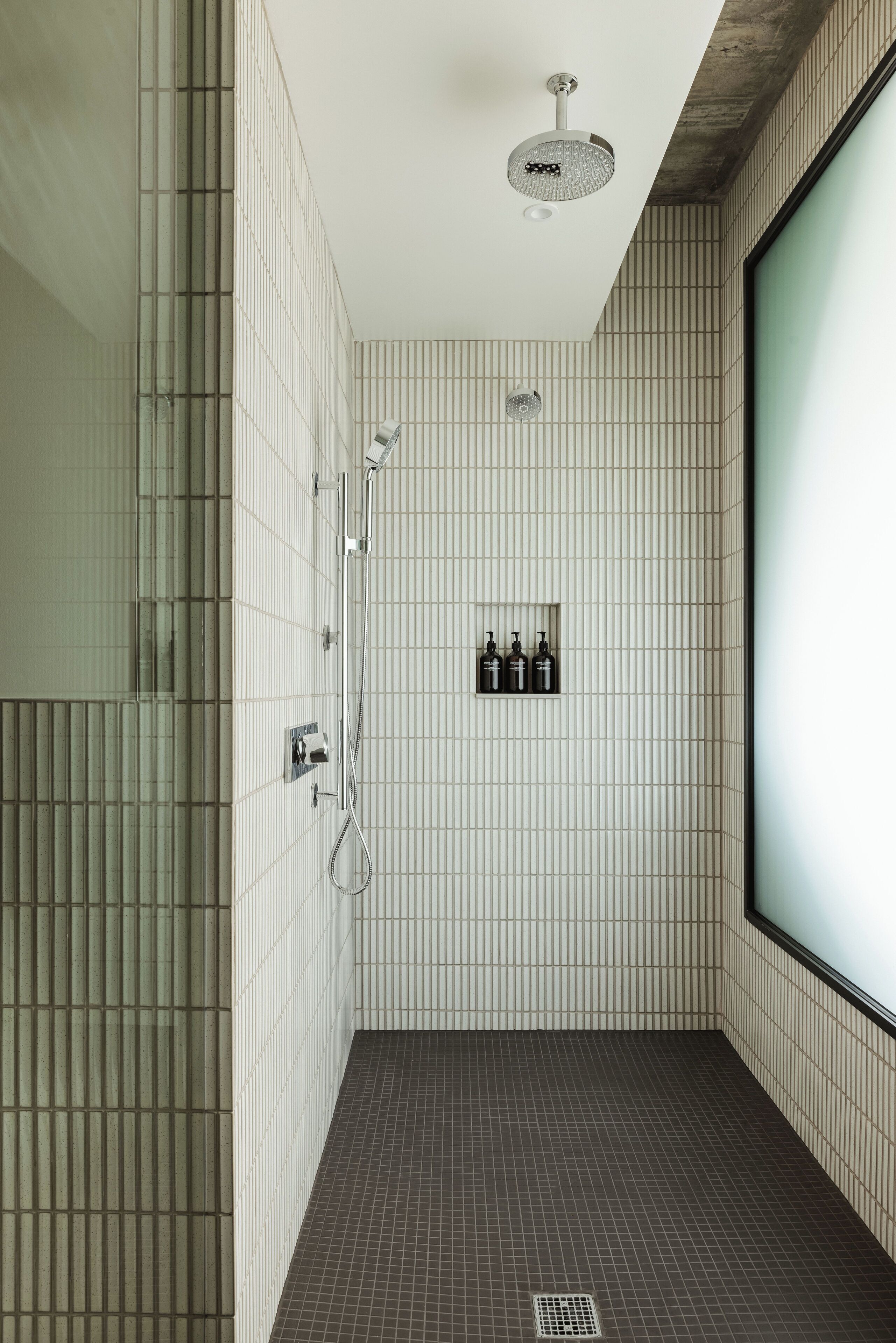 A modern bathroom with a shower, a toilet, and a sink.