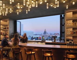 A bar with a view of a cityscape, including a prominent building with a dome. - Populus (Denver)