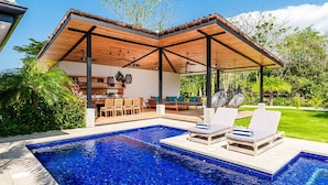 A modern outdoor pool area with a covered seating area and lounge chairs. - Beachside Bliss 4BR Lux Villa, Pool, Terrace, Golf (Pinilla)