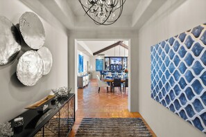Un pasillo con un mueble consola negro, detalles decorativos en la pared y un diseño estampado.