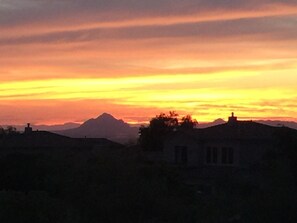 A sunset over a mountainous landscape with buildings silhouetted against the sky. - 2 master suites plus kitchenette in upper level of our townhome  (Mesa)