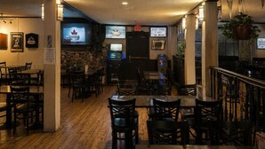 A restaurant interior with wooden tables and chairs, a television screen, and a sign indicating a Canadian theme. - Clydesdale Inn (Surrey)