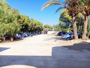 A parking lot with multiple cars, palm trees, and a clear blue sky. - Villa '30 People, Pool, Disco,10 Min Beach' with Mountain View, Wi-Fi and Air Conditioning (Alicante)