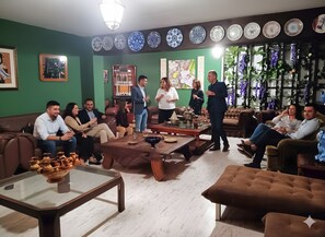 A room with a green wall, multiple seating areas, and a variety of decorative plates on the wall. - Villa '30 People, Pool, Disco,10 Min Beach' with Mountain View, Wi-Fi and Air Conditioning (Alicante)