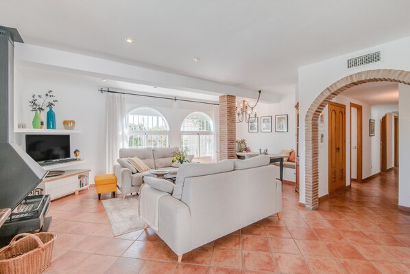 A spacious living area with a sofa, television, and fireplace.