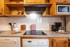 Une cuisine avec des meubles de rangement en bois, un four à micro-ondes, une cuisinière et un lave-vaisselle.