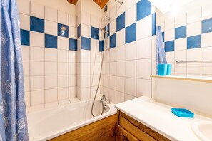 Une salle de bain équipée d’une douche, d’une baignoire, d’un lavabo et de meubles en bois.