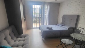 A bedroom with a bed, a sofa, a dining table, and chairs. - 4. Calido Apartaestudio, Casa Azul Manizales Caldas, Colombia (Manizales)