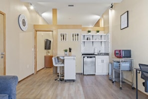 Enjoy casual dining and socializing in this kitchen with a sink, dishwasher, and microwave, plus a dining area with a bar stool and small table.