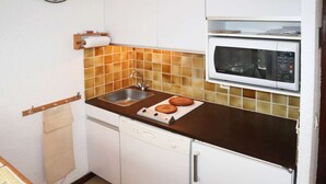 A compact kitchen with a sink, a dishwasher, and a microwave.