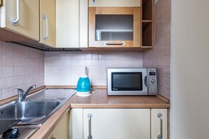 Frigorífico, microondas, placa de cocina y utensilios de cocina