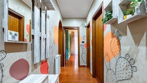 A hallway with a wooden floor, a radiator, and a door leading to another room.