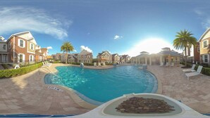 Une piscine dotée d’une zone plus profonde, entourée d’une terrasse dallée et de chaises longues.